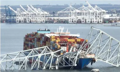  ?? Watson/AFP/Getty Images ?? The steel frame of the Francis Scott Key Bridge sits on top of a container ship in Baltimore, Maryland, on 26 March 2024. Photograph: Jim