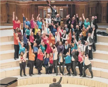  ??  ?? The choirs inside Huddersfie­ld Town Hall, and choirs director William Prideaux (right).