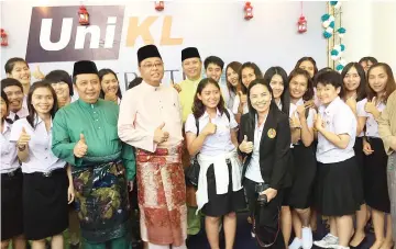  ??  ?? Ismail Sabri (fourth left) and Ahmad Jazlan (third left) with the students from Thailand giving the thumbs up to UniKL during the Mara Hari Raya open house.