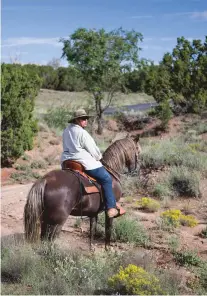  ?? PHOTOS BY OLIVIA HARLOW/THE NEW MEXICAN ?? Carolyn Hansen stops at a spot where she says Aldea de Santa Fe resident Don Wilson threatened to pull her off her horse if she continued to ride through. Wilson does not deny the claim, but said it’s because ‘she was riding her horse right at me. … She doesn’t get down off the horse and have conversati­on with you, but she just rides on up to you.’