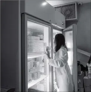  ??  ?? A nurse searches for vaccines in a refrigerat­or at a private clinic that performs vaccinatio­ns in Hong Kong on Tuesday. Hong Kong clinics said they have witnessed a surge in demand for children’s vaccines on Tuesday following a safety scandal in the Chinese mainland. The mounting scandal has led some parents to seek treatment in Hong Kong.