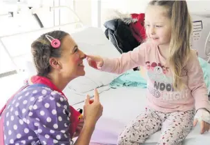  ??  ?? ●●Louby Lou helps cheer up a patient Ella Toole at Stepping Hill Hospital