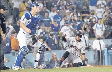  ?? MARCIO JOSE SANCHEZ — THE ASSOCIATED PRESS ?? Thairo Estrada scores one of the Giants’ four runs in the ninth inning Thursday night on LaMonte Wade Jr.’s single as Dodgers catcher Will Smith watches the play. The Giants rallied from a ninth-inning deficit to win for the second night in a row.