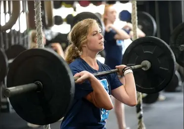  ?? NWA Democrat-Gazette/ANDY SHUPE ?? Molly Kingston, 17, a senior at Har-Ber High School, demonstrat­es a workout the team has been using Wednesday at CrossFit 540 in Springdale. The Springdale Har-Ber volleyball team spent the offseason doing CrossFit workouts to get ready for the season.