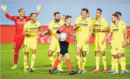  ??  ?? Polémica. Los jugadores del Villarreal protestan ante el colegiado Hernández Hernández durante el duelo ante el Atlético de Madrid por una discutida pena máxima.