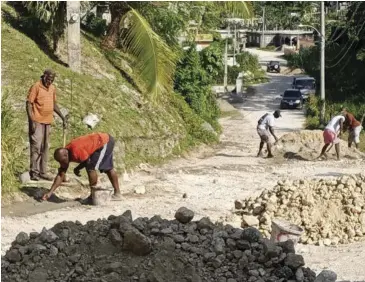  ?? ?? Residents repairing a drain on Hummingbir­d Boulevard in Portland.