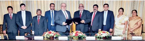  ??  ?? Heinz Reuter - Chairman of Prestige Automobile Pvt. Ltd exchanging the MOU with Jegan Durairatna­m -Managin Director of Commercial Bank PLC in the centre