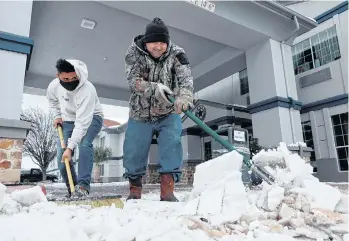  ?? /EFE ?? Sam Pate, (izquierda) y Mike Bollin limpian la entrada del hotel en Benbrook, Texas, donde se han hospedado residentes que han perdido la electricid­ad en su hogares.