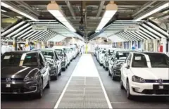  ?? ANDERSEN/AFP ODD ?? Employees of German carmaker Volkswagen check cars at an assembly line in Wolfsburg, central Germany, on October 21, 2015.