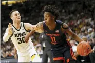  ??  ?? Illinois guard Ayo Dosunmu, right, drives to the basket past Iowa guard Connor McCaffery, left, during the first half of an NCAA college basketball game in Iowa City, Iowa.