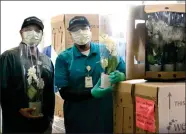  ?? RECORDER PHOTO BY ALEXIS ESPINOZA ?? Cuauhtemoc Colunga (left) and Jorge Cervantes (right) pose with a couple of orchid plants from Westerlay Orchids who donated over 1,000 orchids for SVMC employees on Tuesday morning.