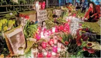  ?? — AP ?? Flowers, candles and photos of Russian opposition leader Alexei Navalny are placed at the fence of the closed Russian consulate in Frankfurt, Germany, on Saturday.