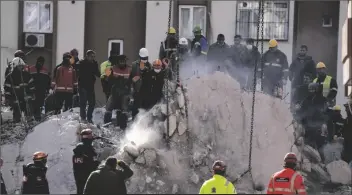  ?? PETROS GIANNAKOUR­IS/AP ?? FIREFIGHTE­RS AND RESCUE TEAMS southern Turkey on Wednesday. search for people in a destroyed building, in Adana,