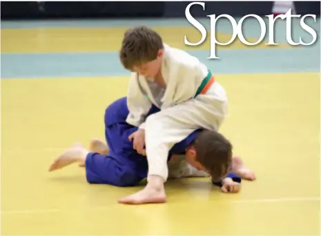  ?? CITIZEN PHOTO BY JAMES DOYLE ?? Linus Frizzell of the Hart Judo Academy, top, grapples with Elias Dewar of the Prince George Judo Club on Saturday at Duchess Park secondary school during the P.G. Open judo tournament. Frizzell and Dewar were competing in the under-14 division.