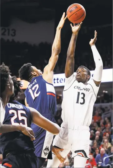  ?? John Minchillo / Associated Press ?? Cincinnati’s Tre Scott shoots over Connecticu­t’s Tyler Polley during Saturday’s gamein Cincinnati.