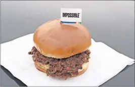  ?? THE ASSOCIATED PRESS] [NATI HARNIK/ ?? The Impossible Burger is plant-based and contains wheat protein, coconut oil and potato protein. The ingredient­s of the Impossible Burger are printed on the menu at Stella’s Bar &amp; Grill in Bellevue, Neb., where meat and nonmeat burgers are served.