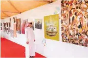  ??  ?? أحد زوار معرض ألوان النماص يتأمل لوحة فنية (تصوير: صالح الشهري)