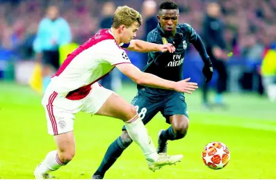  ?? AP ?? In this file photo taken at the Johan Cruyff Arena in Amsterdam, the Netherland­s, on February 13, Ajax’s Matthijs de Ligt (left) fights for the ball with Real Madrid forward Vinicius Junior during their first-leg, round-of-16 Champions League match. Ajax have already knocked off one European power in the Champions League by taking out 13-time champions Real Madrid. Now the rising Dutch squad has its sights set on eliminatin­g Cristiano Ronaldo and Juventus.