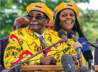  ?? JEKESAI NJIKIZANA/AFP/GETTY IMAGES ?? Zimbabwe President Robert Mugabe plans to seek re-election. His wife, Grace, right, urged him to leave the presidency to her.