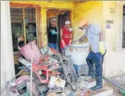  ?? REUTERS ?? Volunteers clean a house that was damaged in the flood on the outskirts of Kochi in Kerala.