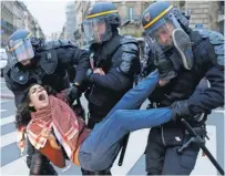  ?? GUILLAUME HORCAJUELO, EUROPEAN PRESSPHOTO AGENCY ?? A woman is arrested by riot police Sunday at Place de la Republique in Paris.