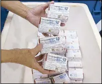  ??  ?? A health worker shows unused packs of antidengue vaccine Dengvaxia before returning it inside a freezer at the Manila Central Vaccine storage in Sta. Cruz, Manila on Dec. 5, 2017.