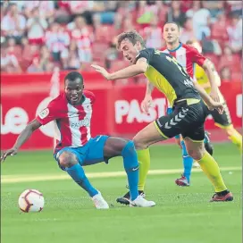  ?? FOTO: LOF ?? Los jugadores de Sporting y Nàstic luchan por un balón ayer en el Molinón.