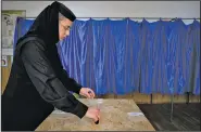  ?? AP/ANDREEA ALEXANDRU ?? A Romanian Orthodox nun casts her vote, in Ciorogarla, Romania, on Sunday on a constituti­onal amendment that would make it harder to legalize same-sex marriage.