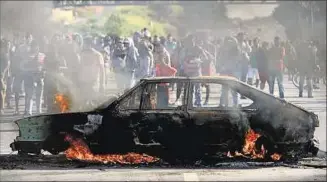  ??  ?? VIOLENCIA. Manifestan­tes prendieron fuego un auto en Ribeirao das Neves, en Belo Horizonte.