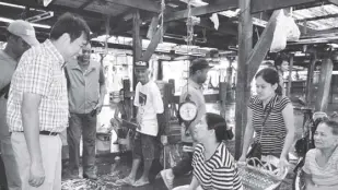  ??  ?? Parañaque Mayor Edwin L. Olivarez visits vendors at the La Huerta Fisherman’s Wharf, locally known as Bulungan, where local fisherfolk land and sell their catch.