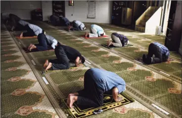  ?? Tyler Sizemore / Hearst Connecticu­t Media ?? Worshipers bow in prayer at the early afternoon jamaat during the holy month of Ramadan at Stamford Islamic Center on Wednesday. The mosque was closed due to COVID last year during Ramadan, but is open this year with safety precaution­s in place. Capacity is limited from 130 to 55.