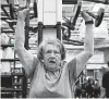  ?? ?? Tidd overhead-presses dumbbells during a workout.