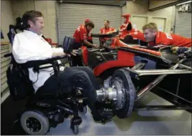  ?? TOM STRATTMAN — THE ASSOCIATED PRESS FILE ?? In this Friday file photo, Indy Racing League car owner Sam Schmidt, left, talks with crew member Mike Sobeleski as he works on the car in the garage area at the Indianapol­is Motor Speedway. Sam Schmidt was left quadripleg­ic from a racing accident and the team he later created has suffered a series of tragedies and setbacks.