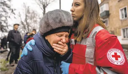  ?? EVGENIY MALOLETKA AP ?? A woman cries in front of the building destroyed by a Russian attack in Kryvyi Rih, Ukraine, on Friday. Officials said at least 60 missiles were launched across the country, the second large-scale attack this week.