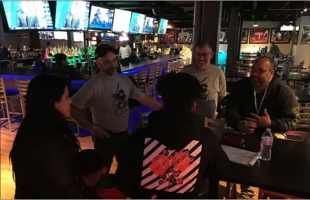  ?? RICHARD PAYERCHIN — THE MORNING JOURNAL ?? Lorain Internatio­nal City Baseball league President Walter Klamer, third from left, and Vice President Pedro Natal, second from right, speak to a prospectiv­e player and his family during a signup session on March 11, at Game On Lorain.