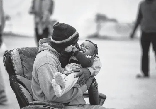  ?? Photos by Marie D. De Jesús / Staff photograph­er ?? A man kisses a baby at the Terraza Fandango migrant shelter in Ciudad Acuña, Mexico, where thousands of Haitians arrived last year, seeking entry into the U.S.