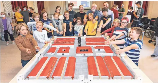  ?? RP-FOTO: LAMMERTZ ?? Stolz auf das Werk mit mehr als 11.000 Legosteine­n: Die kleinen Baumeister von der Kinderuni Zweistein vor der Lego-Nachbildun­g des Römerlager­s Gelduba.Die gesamte Anlage misst 192,5 x 154 Zentimeter. Zwölf Kinder haben mitgebaut.