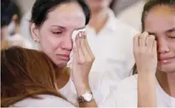  ?? —AP ?? MANILA: Eva Arnaiz, left, the mother of a teenager who was killed in an alleged shootout with police, grieves during his burial ceremony in Manila, Philippine­s.