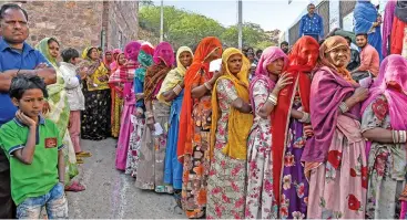  ?? (AFP) ?? Women stand in a queue to cast their vote at a polling station during Rajasthan’s assembly election, in Jodhpur on Friday