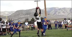  ?? PHOTO BY JOLENE JONES ?? No. 28 Roland Pina catches a pass from No. 12 quarterbac­k Colton Michael, scoring three touchdowns in the day with a solid performanc­e on both offense and defense.