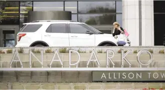  ?? Gary Coronado / Houston Chronicle ?? A woman leaves the Anadarko building in The Woodlands on Thursday after the oil company announced 1,000 job cuts, or 17 percent of its workforce.