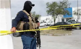  ?? Photograph: Daniel Becerril/Reuters ?? Security forces man a cordon outside the morgue ahead of the transfer of the bodies of two Americans to the US in Matamoros on Wednesday.