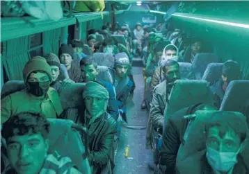  ?? PETROS GIANNAKOUR­IS/AP ?? Men sit in a bus on Nov. 22 in Herat, Afghanista­n, for a 300-mile trip south to the sparsely populated Nimrooz region in an effort to enter Iran. Driven by desperatio­n, about 4,000 to 5,000 Afghans stream into Iran each day.