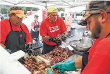  ?? Michael Ciaglo / Houston Chronicle ?? Pitmaster Jeff Petkeviciu­s, center, volunteers with Operation BBQ Relief in Houston.