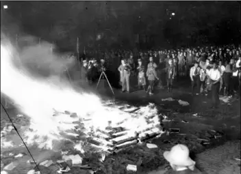  ??  ?? A crowd gathers to witness thousands of books, considered to be “un-German,” burn in Opera Square in Berlin, Germany, during the Buecherver­brennung book burnings on May 10, 1933, in this black and white photo. AP FILE PHOTO