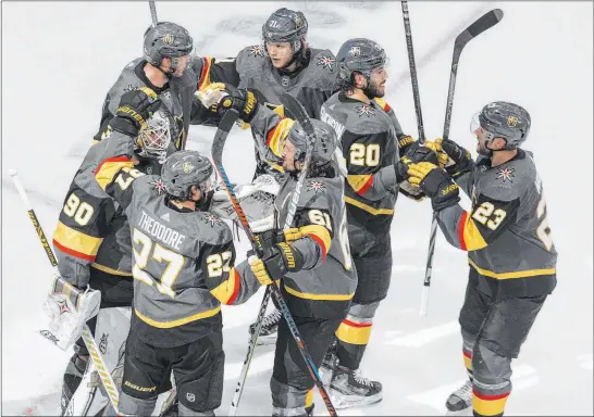  ?? Jason Franson The Associated Press ?? Series over: Knights players congratula­te one another after their 4-3 victory that eliminated the Blackhawks. The Knights won the best-of-seven series in five games.