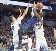  ?? BILL STREICHER/USA TODAY SPORTS ?? Magic forward Jonathon Simmons attempts a shot against 76ers forward Dario Saric and forward Richaun Holmes.