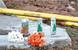  ?? SCOTT ROGERS/THE TIMES VIA AP ?? Candles and flowers are left along Centennial Drive recently near Foundation Food Group in Gainesvill­e, Ga.