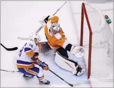  ?? COLE BURSTON - VIA THE CANADIEAN PRESS ?? Flyers goaltender Carter Hart, right, stops a shot by New York Islanders left wing Anthony Beauvillie­r in the first period Wednesday. The Flyers blew a 3-0 lead but won in overtime, 4-3, to tie the series, 1-1.
