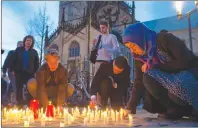  ?? AP PHOTO ?? People light candles during a memorial service in front of the Muenster, western Germany, cathedral Sunday, one day after a man killed two people and injured 20 others by crashing into people drinking outside a popular bar before killing himself.